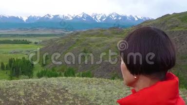 在寒冷的阴天，女徒步旅行者骄傲地站在山顶上。 站在山顶上的女人。 近距离空中飞行